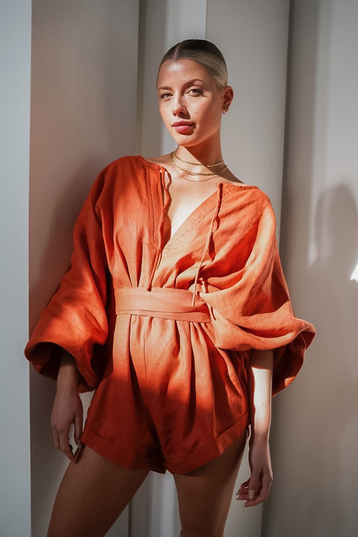 The Ease Label - Keros romper - terracotta. Linen batwing romper playsuit in an earthy orange red. 