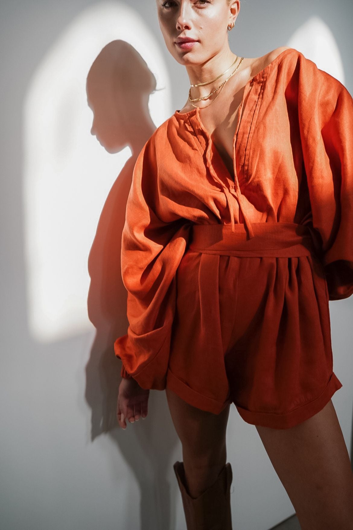 The Ease Label - Keros romper - terracotta. Linen batwing romper playsuit in an earthy orange red. 
