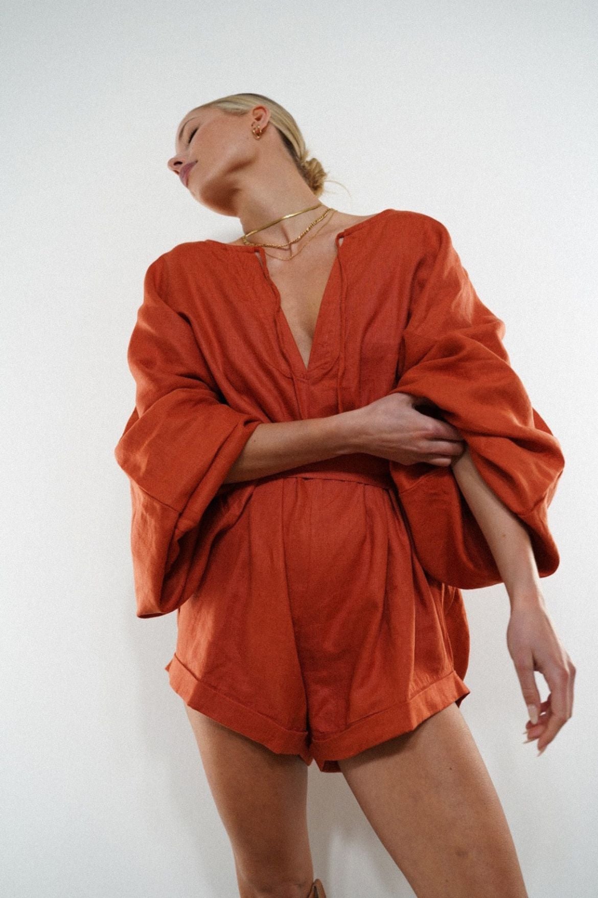 The Ease Label - Keros romper - terracotta. Linen batwing romper playsuit in an earthy orange red. 