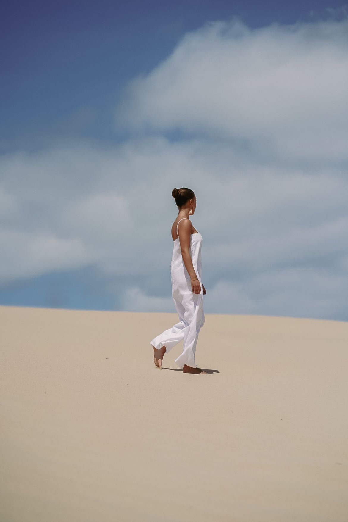 The Ease Iris Jumpsuit - White linen jumpsuit with spaghetti straps to hang off the body