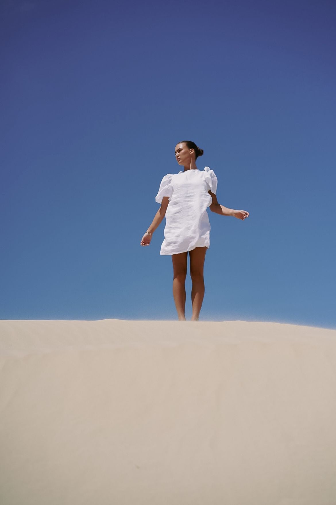 The Ease Florence Mini Dress - White linen mini dress with exaggerated sleeve and tie back