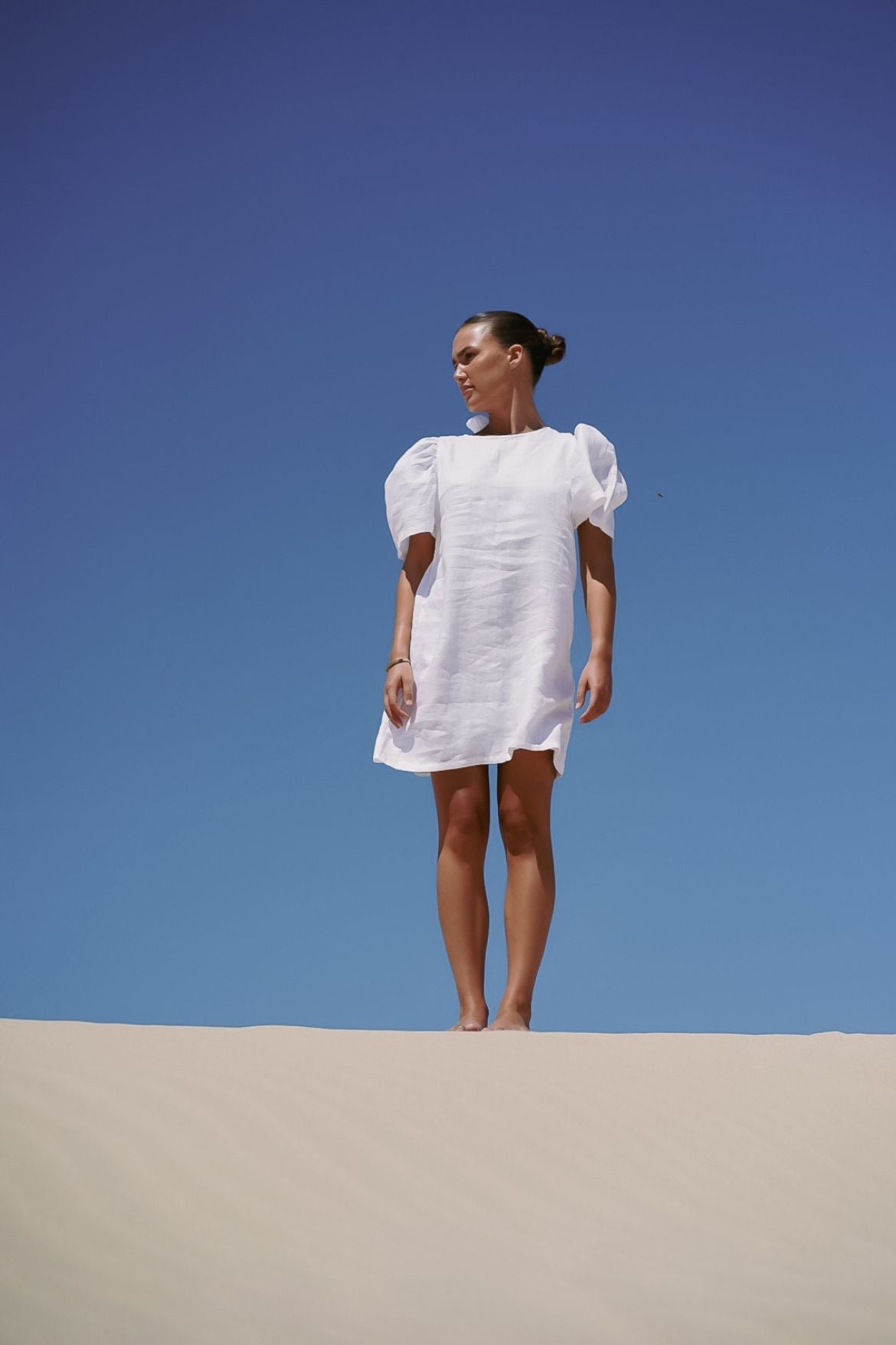 The Ease Florence Mini Dress - White linen mini dress with exaggerated sleeve and tie back